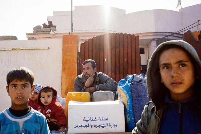 An Iraqi family wait with their belongings to return home on the western edge of Al-Intisar neighbourhood in southeastern Mosul, northern Iraq on January 5, 2017