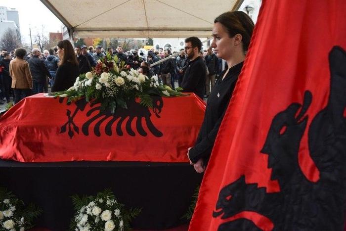 Kosovo Albanians pay their respects beside the casket of opposition activist Astrit Dehari after his death in prison, which authorities said was suicide