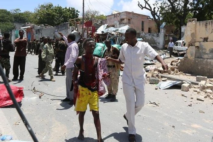 A civilian wounded following a car bomb claimed by al Shabaab Islamist militants  outside the president's palace is escorted as he walks from the scene of the explosion in the Somali capital of Mogadishu, August 30, 2016. REUTERS/Feisal Omar