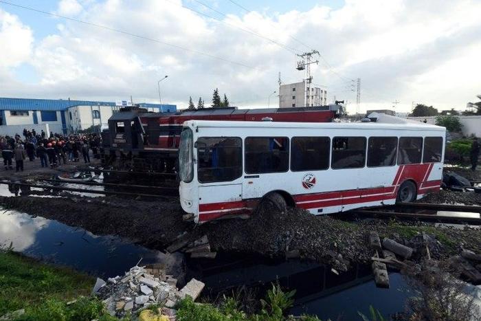 Tunisian security officers inspect the wreckage after a train smashed into a bus near Sidi Fathallah, on December 28, 2016