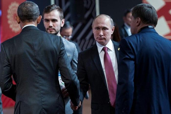 US President Barack Obama (L) and Russia's President Vladimir Putin (2ndR) shake hands before an economic leaders meeting on November 20, 2016 in Lima