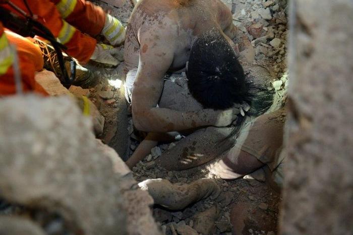 Rescuers save three-year-old Wu Ningxi, who was protected by the body of her dead father more than 12 hours after four buildings collapsed in Wenzhou, eastern China on October 10, 2016