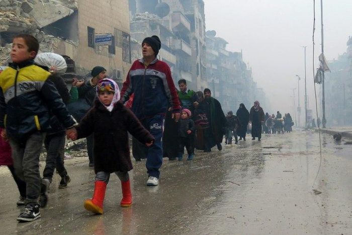 Syrian residents, fleeing violence in the restive Bustan al-Qasr neighbourhood, arrive in Aleppo's Fardos neighbourhood on December 13, 2016