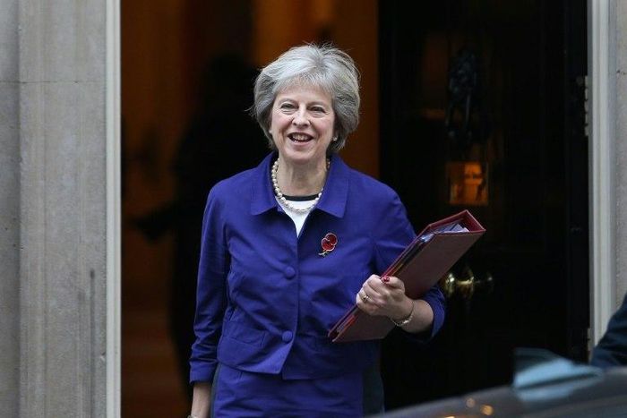 Theresa May wears a poppy as she leaves 10 Downing Street on November 2, 2016, to go to Parliament