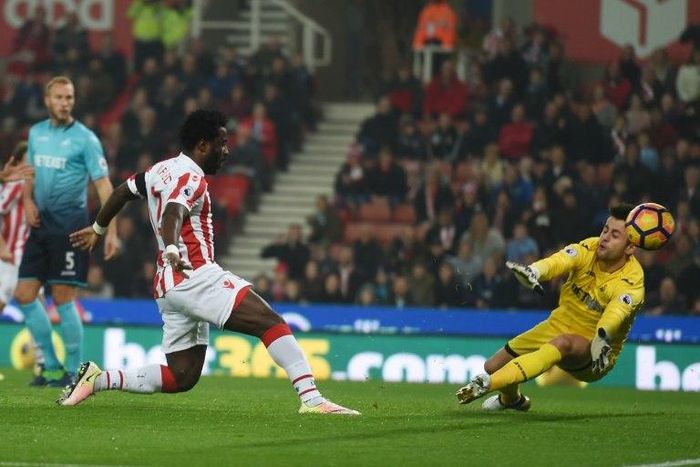 Stoke City's striker Wilfried Bony (L) shoots and scores past Swansea City's goalkeeper Lukasz Fabianski during the English Premier League football match between Stoke City and Swansea in Stoke-on-Trent, central England on October 31, 2016