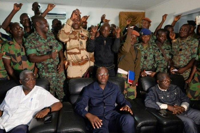 A delegation of mutinous Ivorian soldiers stand behind Defence Minister Alain-Richard Donwahi (C) as he speaks to journalists in Bouake, on January 7, 2017