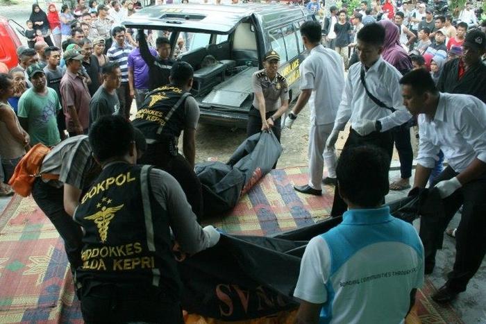 Indonesian police unload the bodies of victims after a boat carrying migrant workers capsized and sunk off Batam island