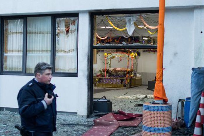 A police officer walks in front of the Sikh temple in Essen, western Germany, where an explosion took place at a wedding on April 16.