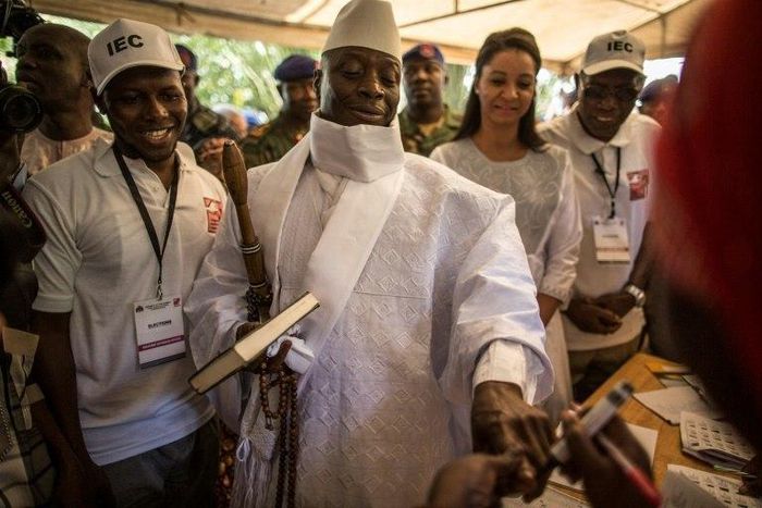 Incumbent Gambian President Yahya Jammeh (C) has his finger inked before casting his marble in a polling station in Banjul on December 01, 2016