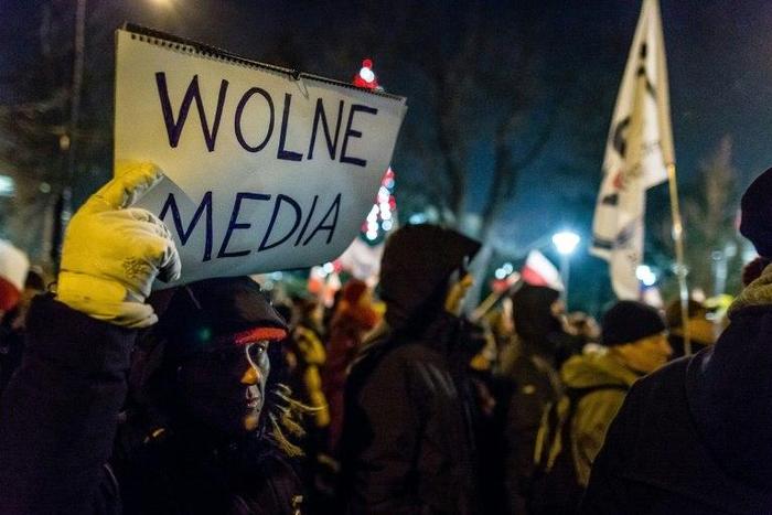 A protester holds a sign reading "Free media" as people gather for an anti-government demonstration by opposition supporters and Committee for the Defence of Democracy movement (KOD) outside the Polish parliament on December 16, 2016