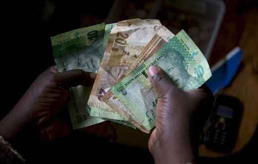 A shopkeeper counts out change above her cash box at her shop in Hillcrest, west of Durban, South Africa, January 11, 2016. REUTERS/Rogan Ward