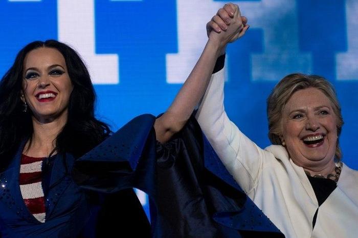 Singer Katy Perry (L) and Democratic presidential nominee Hillary Clinton cheer during a GOTV concert in Philadelphia, Pennsylvania