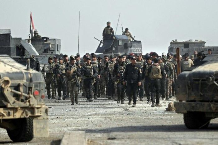 Iraqi Special Forces parade with Staff Lieutenant General Abdul Ghani Al-Asadi, commander of the Counter-Terrorism Service in a recently recaptured district of southeast Mosul, on November 27, 2016
