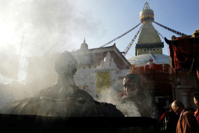 A Buddhist devotee lights incense at Kathmandu's Boudhanath stupa on November 22, 2016