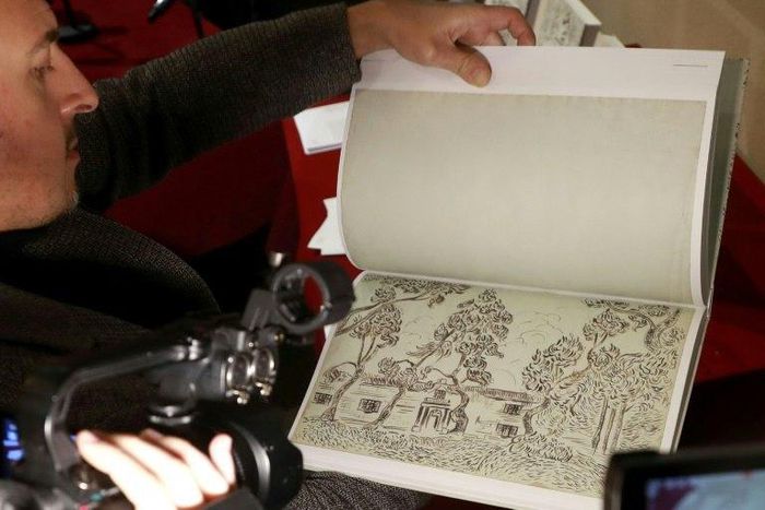 A man leafs through the pages of a new book of drawings supposedly by Dutch post-impressionist painter Vincent Van Gogh at the architecture academy in Paris on November 15, 2016