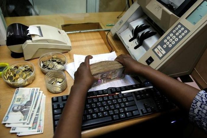 A teller arranges Kenya shilling coins and notes inside the cashier's booth at a forex exchange bureau in Kenya's capital Nairobi, April 20, 2016. REUTERS/Thomas Mukoya