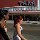 Cubans walk past a movie theater announcing the Havana Latin American Film Festival