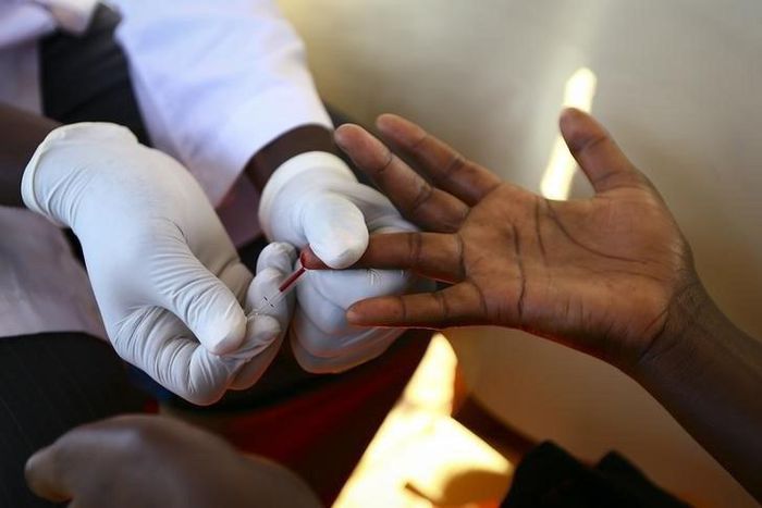 A doctor draws blood from a man to check for HIV/AIDS at a mobile testing unit in Ndeeba, a suburb in Uganda's capital Kampala May 16, 2014.