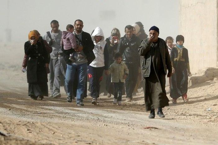 Iraqis walk as they flee their neighbourhoods to safer locations on November 28, 2016 in an eastern district of the city of Mosul during the ongoing figthing between Islamic State group jihadists and government forces