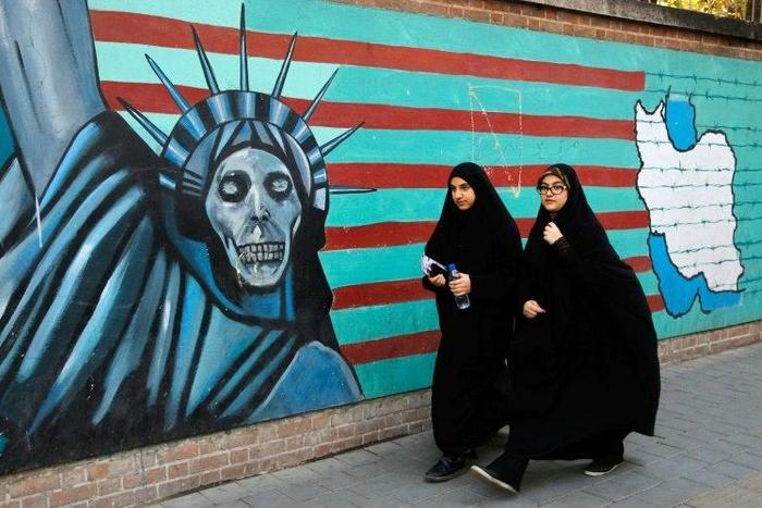 Iranian women walk past the former US embassy in Tehran on November 3, 2016, during a demonstration marking the start of its 1979 siege