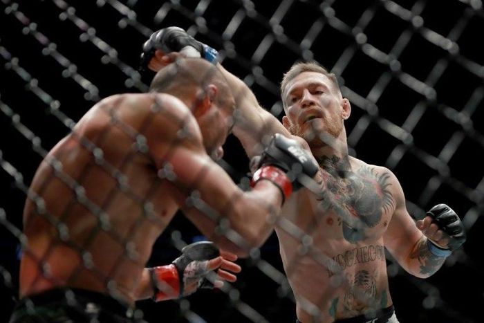 Ireland's hugely popular UFC featherweight champion Conor McGregor (R) knocked Eddie Alvarez down three times in the first round before finishing him off in the second