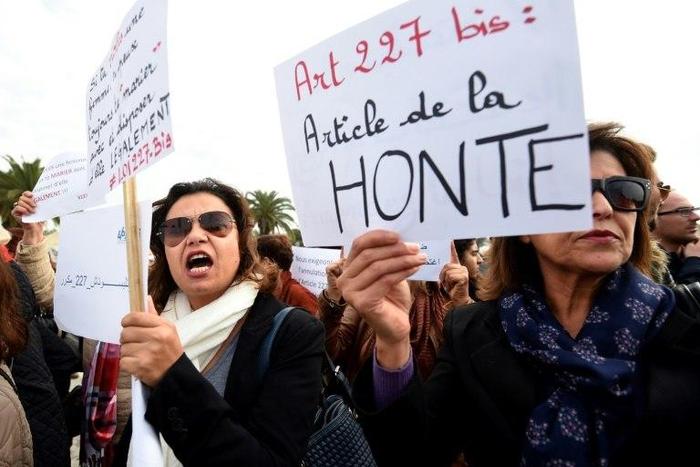 Dozens of people stage a protest outside of Tunisian parliament denouncing a law that allows men who rape underage girls to avoid punishment by marrying their victims