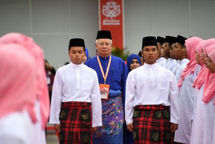 Malaysian Prime Minister Najib Razak (C) inspects a ceremonial guard of honour during the annual congress of his ruling party, the United Malays National Organisation (UMNO)