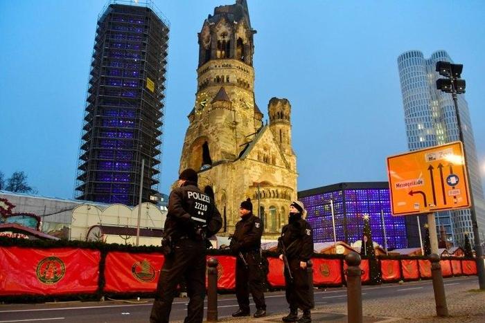 Policemen stand on December 20, 2016 in front of the Kaiser-Wilhelm-Gedaechtniskirche in Berlin, where a truck crashed the day before into a Christmas market