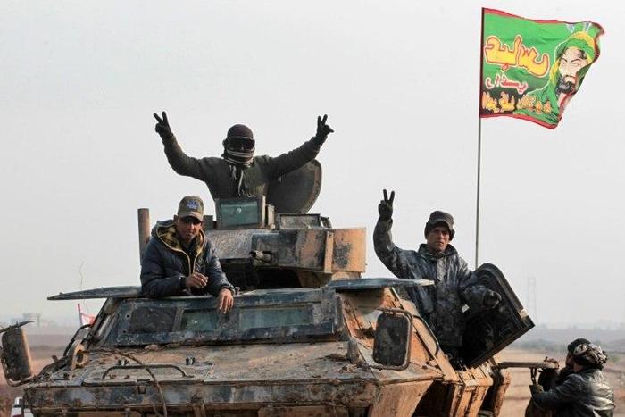 Iraqi forces members advance in the village of Arabat, south of Mosul, as temperatures continue to drop, on December 1, 2016