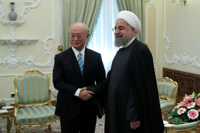 Iranian President Hassan Rouhani (R) greets Yukiya Amano (L), Director General of the International Atomic Energy Agency (IAEA) on December 18, 2016
