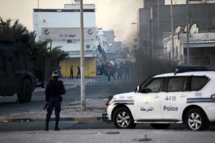 Protesters throw stones towards riot police during clashes in the Shiite village of Shahrakkan, south of Manama on April 5, 2016 following the funeral of a 17-year-old whose family says he died of injuries suffered in a police chase