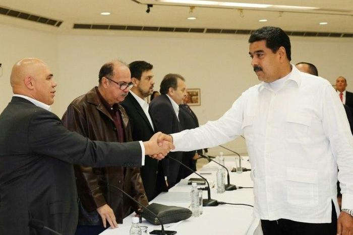 Venezuela's President Nicolas Maduro (right) shakes hands with opposition spokesman Jesus Torrealba at Vatican-backed talks aimed at settling a deepening political crisis in Caracas on October 30, 2016