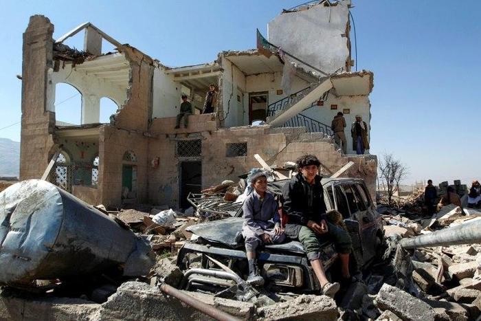 Children sit amidst the rubble of a house hit by Saudi-led coalition air strikes on the outskirts of the Yemeni capital Sanaa