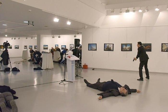 This picture taken on December 19, 2016 shows Andrei Karlov, the Russian ambassador to Ankara, lying on the floor after being shot by a gunman (R) during a public event in Ankara