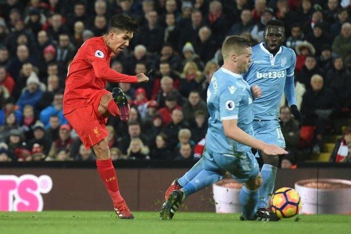 Liverpool's midfielder Roberto Firmino (L) scores Liverpool's second goal during the English Premier League football match between Liverpool and Stoke City at Anfield in Liverpool, north west England on December 27, 2016