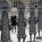 A woman photographs the sculptures "Black and Blue: The invisible Man and the Masque of Blackness", by artist Zak Ove, at Somerset House in London, Britain October 4, 2016.