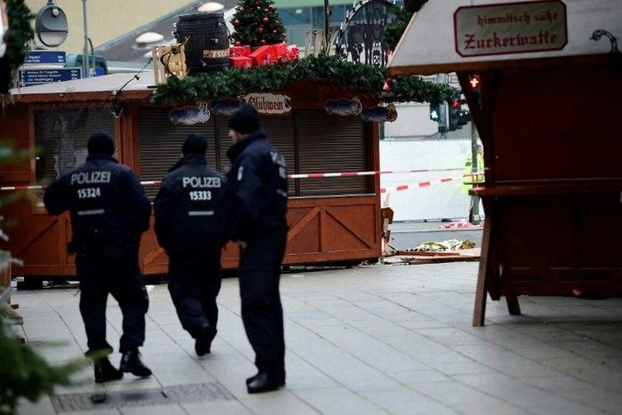 Police patrol the area near the Kaiser Wilhelm Memorial Church, where a speeding lorry crashed into a packed Berlin Christmas market, killing 12 people and injuring dozens