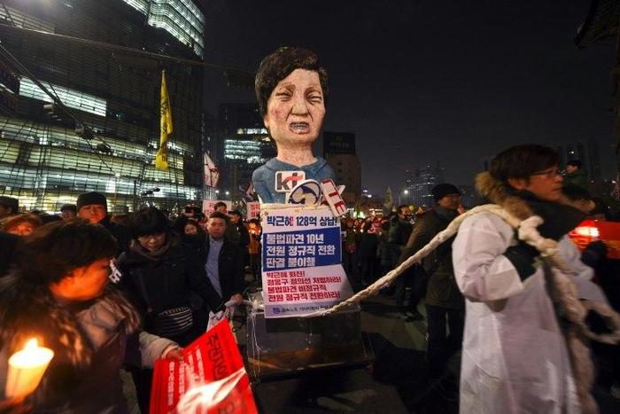 South Korean protesters carry an effigy of President Park Geun-Hye during a rally against the scandal-hit president in central Seoul on December 17, 2016