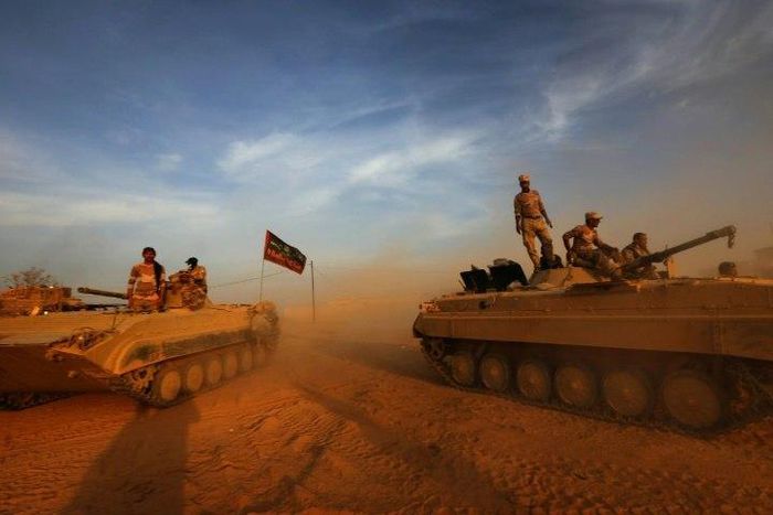 Iraqi forces stand on their BMP-1 vehicles in Jarif, 45km south of Mosul