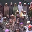 This video grab image created on August 14, 2016 taken from a video released on Youtube purportedly by Boko Haram showing what is claimed to be one of the groups fighters at an undisclosed location standing in front of alleged Chinok Girls 