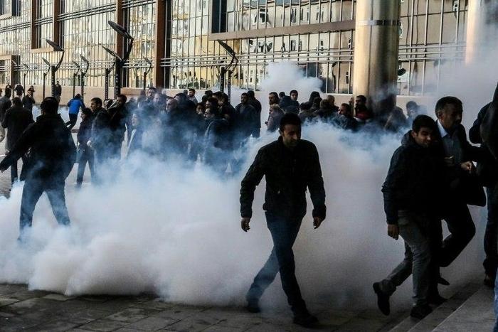 Demonstrators walk away as Turkish riot police use tear gas and water cannon to disperse protestors outside the municipalty headquarters in Van, eastern Turkey on November 17, 2016
