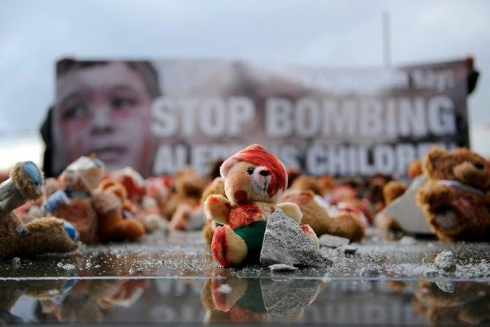 Colour-smeared teddy bears are laid by campaign group Avaaz in Berlin to protest the bombing of Aleppo ahead of a meeting of leaders of Russia, France and Germany