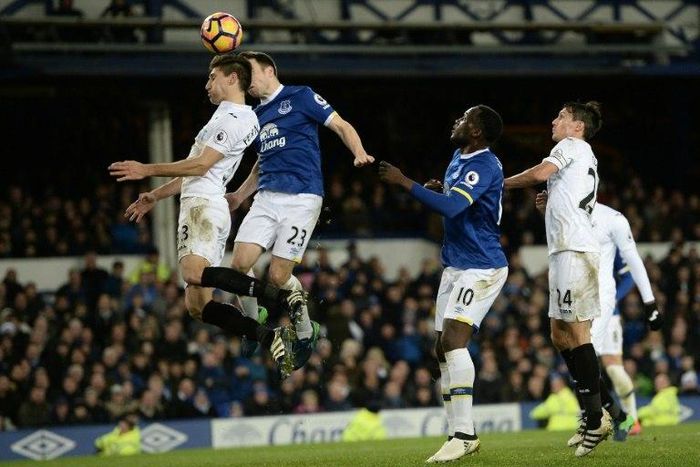 Everton's Seamus Coleman (2L) heads the ball to score his team's first goal against Swansea on November 19, 2016