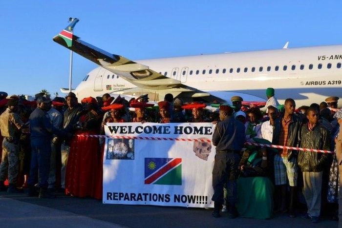 Protesters hold a banner at Windhoek international airport calling for reparations from Germany, on October 4, 2011