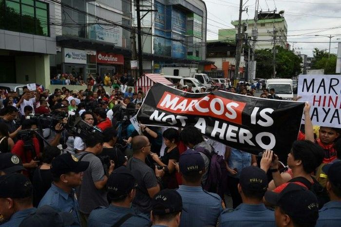 Anti-Marcos protesters (R) face off with pro-Marcos supporters (L) waving miniature national flags while the late dictator Ferdinand Marcos was being given a hero's burial in Manila on November 18, 2016
