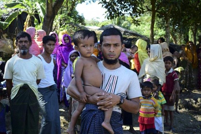 Rohingya refugee Mohammad Ayaz holds his son Mohammad Osman, the two survivors of their family, at an unregistered refugee camp at Ukhiya in southern Cox's Bazar district of Bangladesh on November 24, 2016