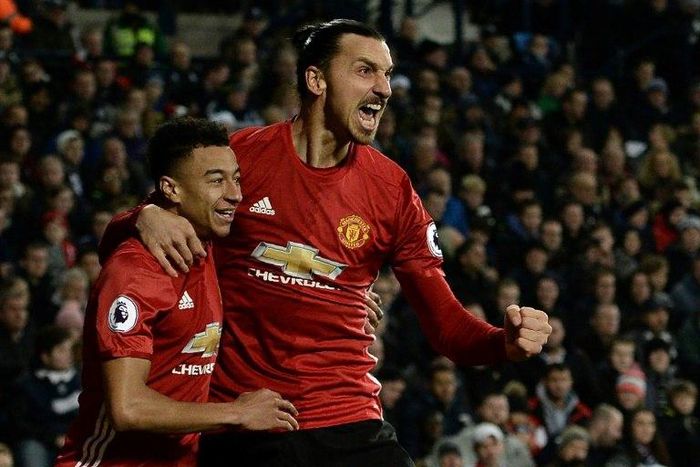 Manchester United's Zlatan Ibrahimovic (R) celebrates with Jesse Lingard after scoring the opening goal against West Bromwich Albion on December 17, 2016