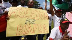 Demonstrators from the Indigenous People of Biafra (IPOB) group wave flags and hold a sign reading "Freedom for Biafra" during a protest in Abidjan on September 23, 2016 calling for the release of pro-Biafra leader Nnamdi Kanu