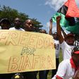 Demonstrators from the Indigenous People of Biafra (IPOB) group wave flags and hold a sign reading "Freedom for Biafra" during a protest in Abidjan on September 23, 2016 calling for the release of pro-Biafra leader Nnamdi Kanu