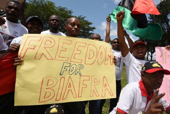 Demonstrators from the Indigenous People of Biafra (IPOB) group wave flags and hold a sign reading "Freedom for Biafra" during a protest in Abidjan on September 23, 2016 calling for the release of pro-Biafra leader Nnamdi Kanu